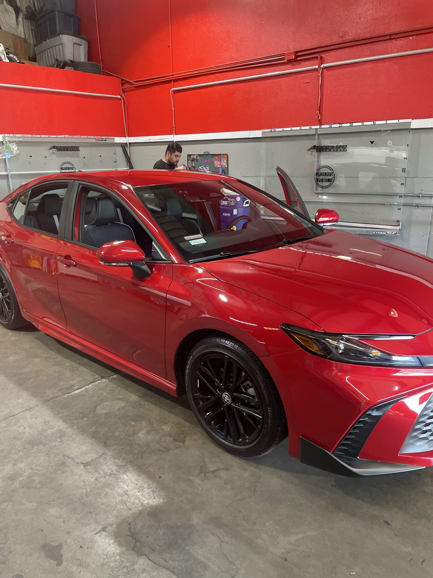 A new red Toyota Camry in the shop bay