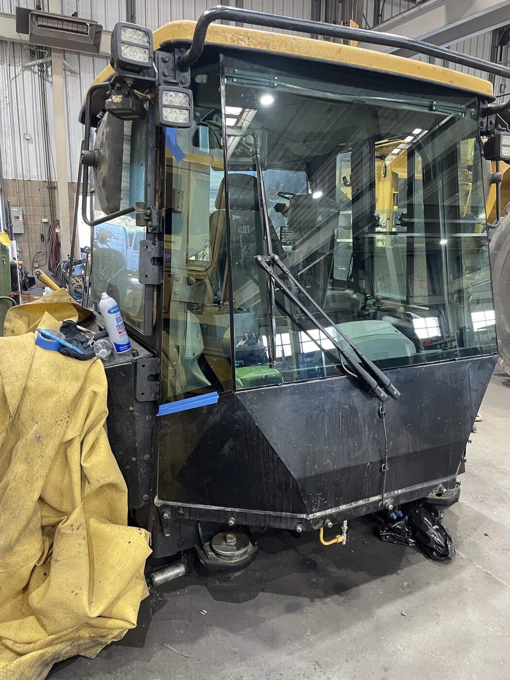 A street sweeper cab getting new glass in the shop